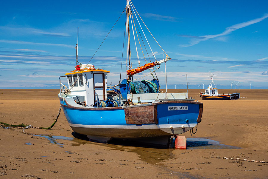 Fishing boat at low tide on the Wirral shore at Moreton